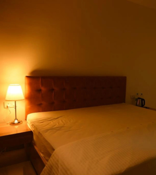Deluxe Room view showcasing bedding and furniture at Hotel Hibiscus Tree